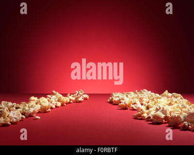 shot of cinema style popcorn on a red background with spotlight and copy space. Stock Photo