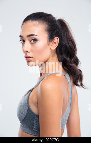 Side view portrait of a beautiful sports woman looking at camera isolated on a white background Stock Photo