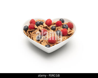 simple shot of bran flakes cereal with blueberries and strawberries added on a pure white background with copy space and a clipp Stock Photo