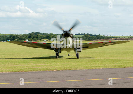 Front view of a single Spitfire aircraft, isolated on an airfield with engine/propeller running. Stock Photo