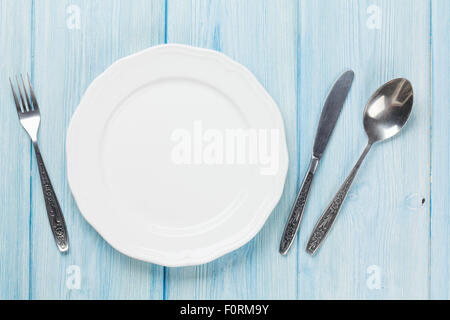 Empty plate and silverware over wooden table background. View from above with copy space Stock Photo