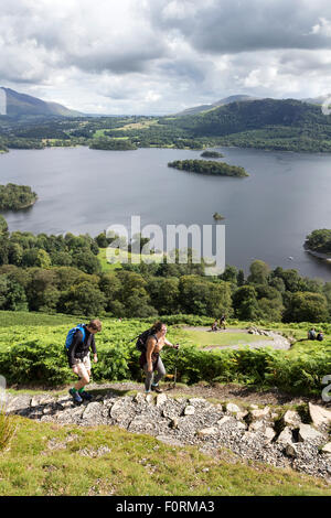 Walkers on the Lower Slopes of Catbells with Derwent Water Below, Lake District, Cumbria UK Stock Photo