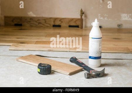 Tools and glue beside a newly laid wooden floor Stock Photo