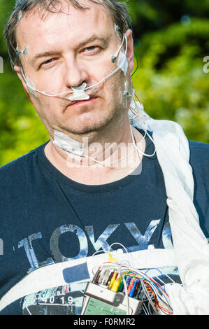 A middle aged man wears polysomnography equipment to measure brain activity, breathing and movement during sleep. Stock Photo