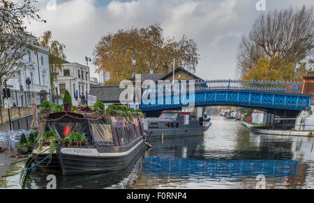 A narrowboat moored on the tow path with a blue bridge over The Regents Canal in Little Venice ,London,UK Stock Photo