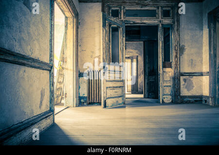 Room in old abandoned home with doors leading to other rooms Stock Photo