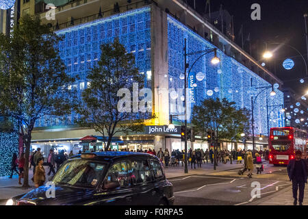 John Lewis department store on a busy Oxford St crowded with Christmas shoppers with The Oxford St Christmas lights on display, London , UK Stock Photo