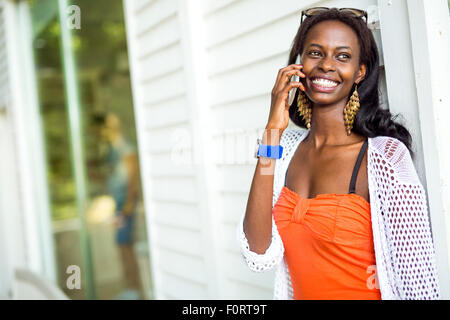 Beautiful black woman talking on phone and smiling during a summer day Stock Photo