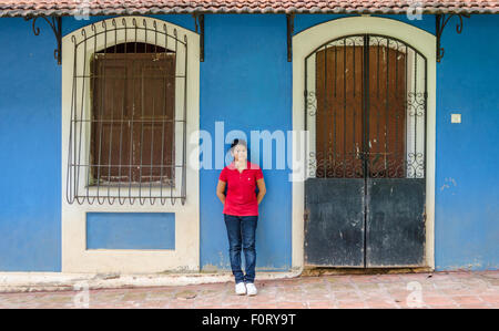 Goan girl standing in front of a royal blue Portuguese house in Fontainhas, Panaji (Panjim), Goa, India Stock Photo