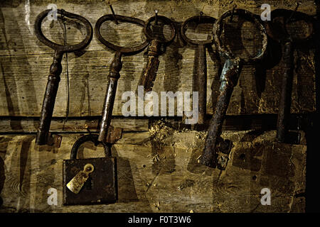 old rusty lock and keys hanging on a wooden wall Stock Photo