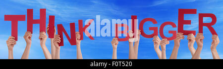 People Hands Holding Red Word Think Bigger Blue Sky Stock Photo