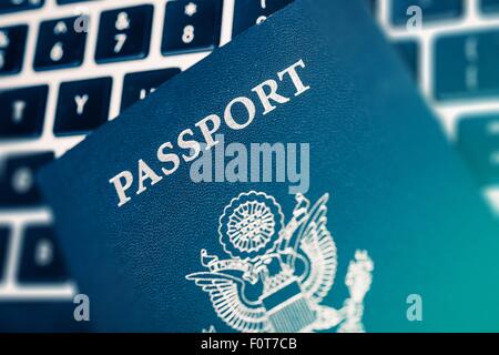 Online Travel Planning Concept Photo. United States of America Passport on the Computer Keyboard Closeup Photo. Stock Photo