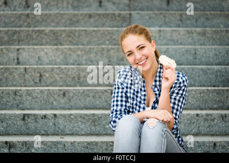 Healthy lifestyle  - teenager eating puffed bread outdoor sitting on stairs Stock Photo