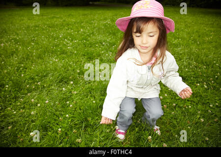 Young girl searching for a four leaved clover Stock Photo