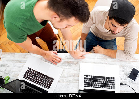 Two young colleagues sharing some ideas in the office Stock Photo