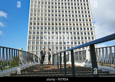 Low angle view of business people standing at top of stairway, City Hall East, Los Angeles, California, USA Stock Photo
