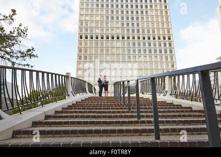 Low angle view of business people standing at top of stairway, City Hall East, Los Angeles, California, USA Stock Photo