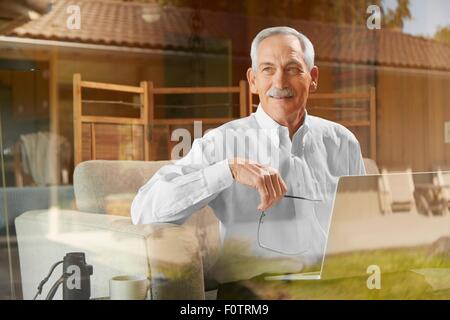 Senior man at home, using laptop Stock Photo