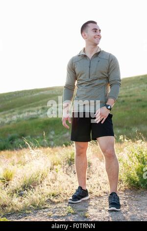 Portrait of young male runner on hillside Stock Photo