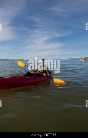 Young man in kayak holding paddles, looking at camera, Great Salt Lake, Utah, USA Stock Photo