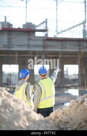 Rear view of surveyor and builder on construction site Stock Photo