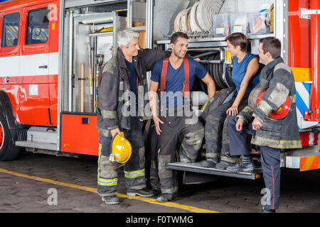 Firefighters Conversing By Firetruck Stock Photo