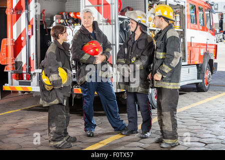 Portrait Of Confident Firefighter Standing With Team Stock Photo