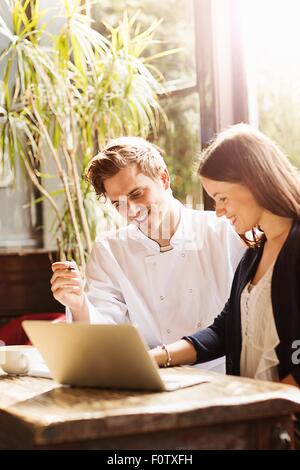 Couple at work in bar with laptop Stock Photo