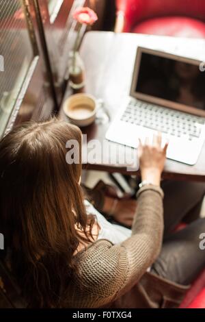 Mid adult woman using laptop, high angle view Stock Photo
