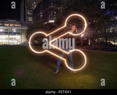 Artist painting share symbol outside office building at night Stock Photo