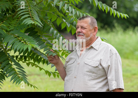 Outdoor portrait of a bearded senior man in light shirt enjoying the nature Stock Photo