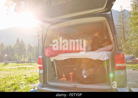 Mother and two sons waking up in camper van, Lake Toblach, Dolomites, South Tyrol, Italy Stock Photo