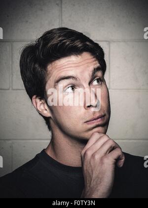 Portrait of young man posing with hand on chin before workout Stock Photo