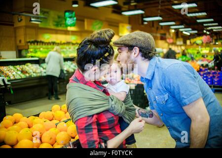 Father kissing baby son in supermarket Stock Photo