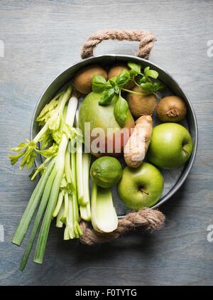 Pan of fresh fruit and vegetables with celery, mango, ginger root and apples Stock Photo