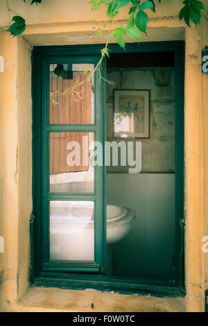 Partly open old window with partial view of wash basin without people Stock Photo
