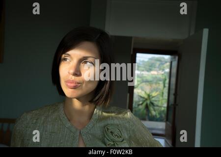 Portrait of beautiful sunlit mid adult woman in hallway Stock Photo