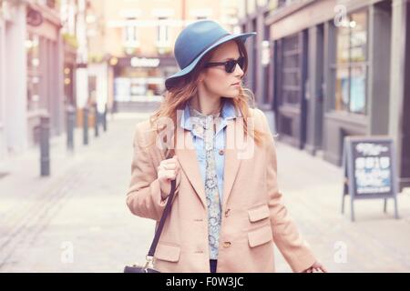 Stylish young female shopper strolling on street, London, UK Stock Photo