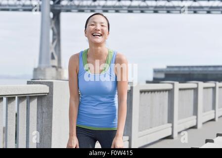 Female runner taking break on bridge, San Francisco, California Stock Photo