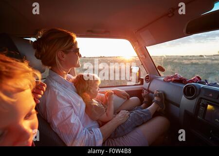 Mother and sons travelling in vehicle, Nxai Pan National Park, Kalahari Desert, Africa Stock Photo