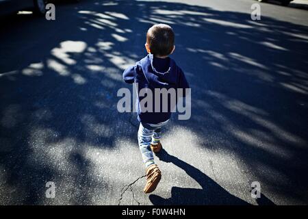 Boy running on road Stock Photo