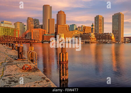 Boston Habor Sunrise - A view during sunrise to the Boston Harbor with the Boston Financial District's dramatic skyline.  Seen is Rowes Wharf, the Odyssey Cruise Yacht, along with other high rises along the waterfront. Stock Photo