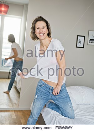 Portrait of a mature woman kneeling on the floor and smiling Stock ...