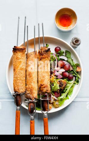 Spring rolls on skewers with salad and dipping sauce Stock Photo