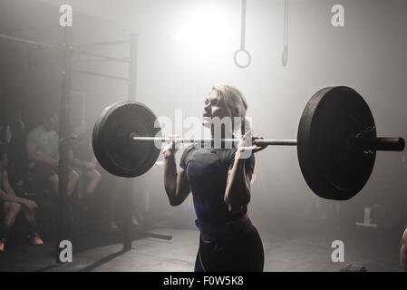 Young woman lifting barbell Stock Photo