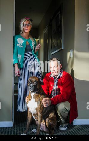 Couple in hallway with boxer dog looking at camera Stock Photo