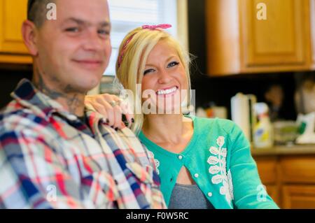 Young woman with hand on man's shoulder, smiling Stock Photo