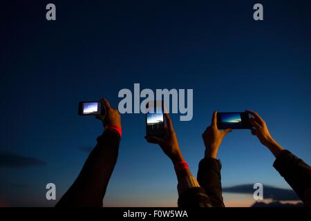 Friends taking photograph with smartphone at dusk Stock Photo
