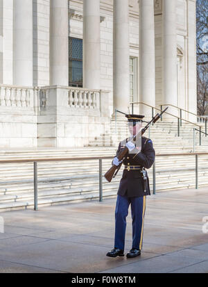 A soldier from the Honot Guard in front of the Memorial Amphitheater marches one of the 21 steps guarding the Tomb of the Unknowns at Arlington National Cemetery in Arlington, VA, is also known as the Tomb of the Unknown Soldier Stock Photo