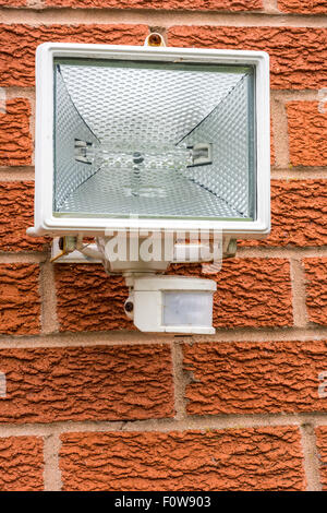 A security light with an automatic motion detection sensor on the side of a house Stock Photo